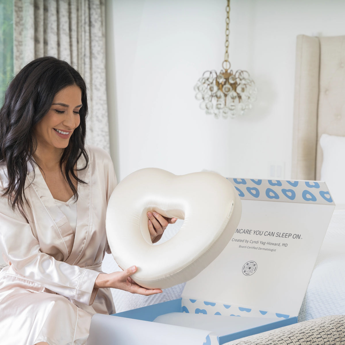 Woman holding the Longevity Pillow with the box